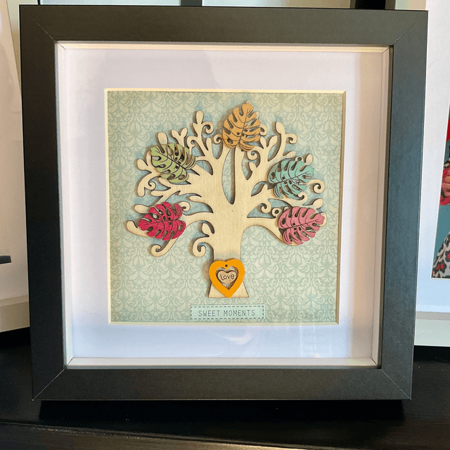 Wooden tree frame with colourful wooden leaves. Sweet moments quote.