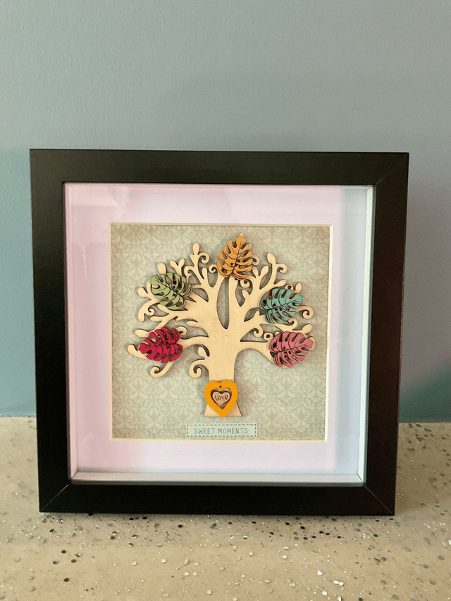 Wooden tree frame with colourful wooden leaves. Sweet moments quote.